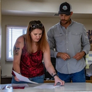 A Big Horn Heating & Cooling team member reviewing papers with a homeowner
